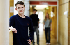 Smilende dreng og to elever i baggrunden