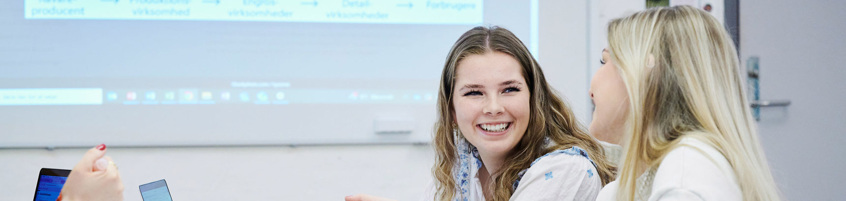 2 studerende der arbejder på deres computer under undervisning