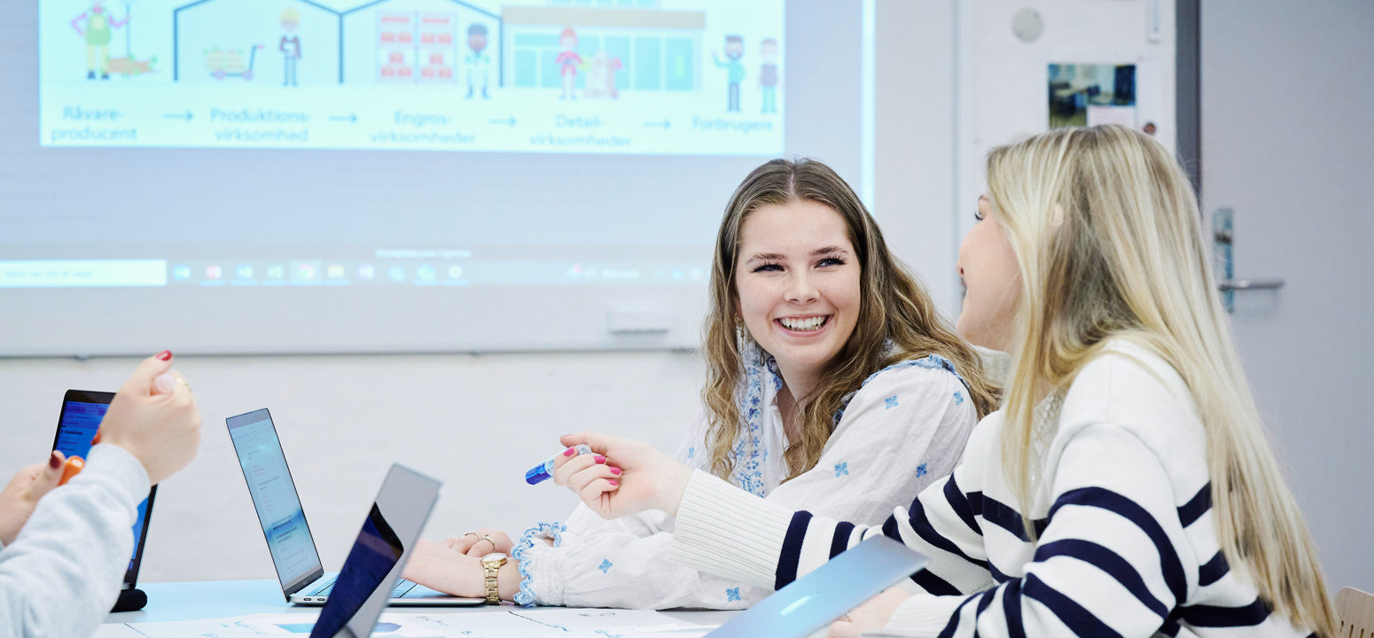 2 studerende der arbejder på deres computer under undervisning